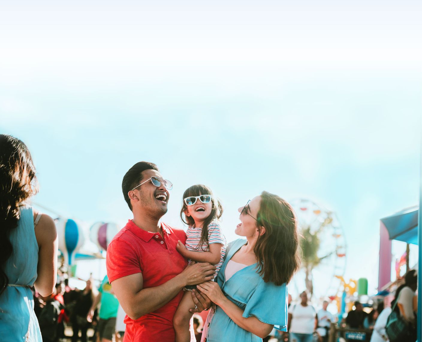 A family laughing at an amusement park.