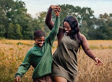 A loving mother and her charming son share a warm smile as they look at each other in the park.