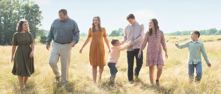 A family walking through the prairie on a warm day