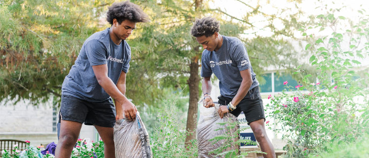 Two young men participating in community cleanup