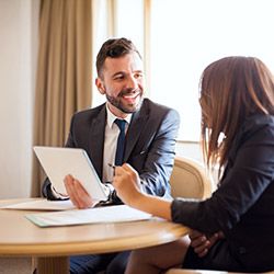 Sales rep talking with his client at a table.